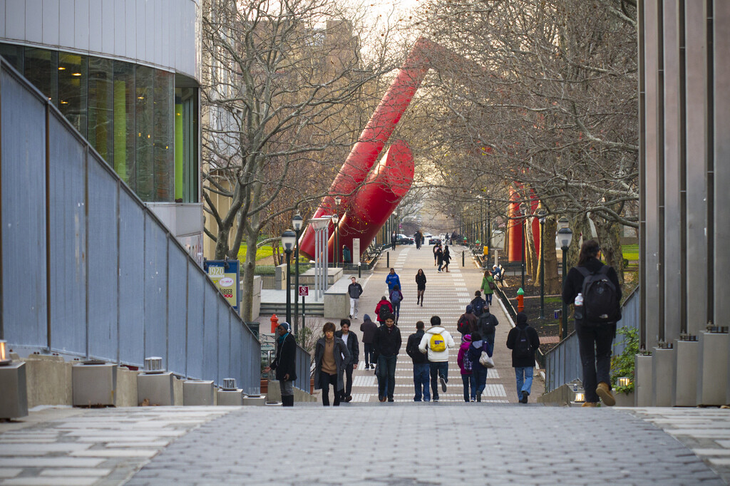 people walking across the locust walk generational bridge